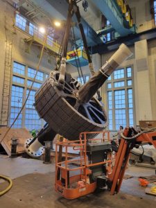 hydroelectric turbine generator rotor being lifted into a vertical position by LGH pneumatic chain hoists